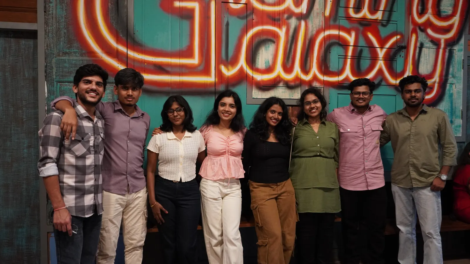 Group photo in front of the Gamingalaxy neon venue sign in Whitefield Bengaluru